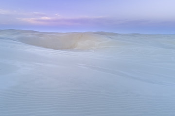 Pristine white sand dunes at dawn with copy space