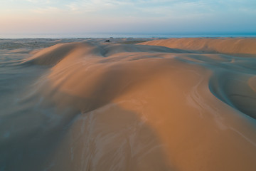 Untouched sand dunes glowing in orange sunrise light. Anna Bay, New South Wales, Australia