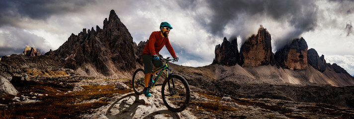 Cycling man riding on bikes in Dolomites mountains andscape. Cycling MTB enduro trail track....