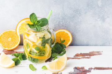 Lemonade drink of soda water, lemon and mint leaves in jar on light background. Copy space