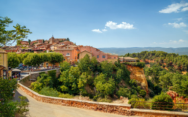 Fototapeta na wymiar Panoramic view of hilltop medieval ocher village of Roussillon, one of the most beautiful villages of France, in a sunny summer day. Provence, Vaucluse, travel France.