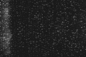 Dirty window glass with drops of rain. Atmospheric monochrome dark background with raindrops....