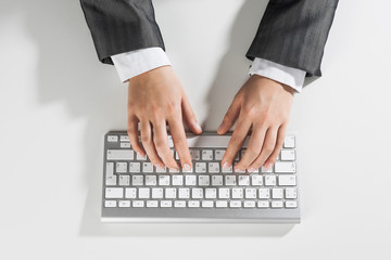Fototapeta na wymiar Closeup of businesswoman hand typing on keyboard with mouse on wood table