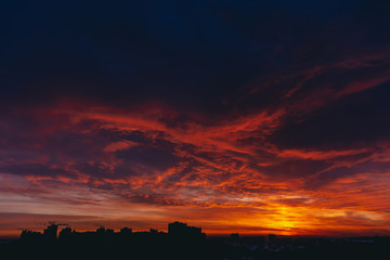 Fiery red blood vampire dawn. Amazing warm dramatic fire blue dark cloudy sky. Orange sunlight....