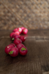 Top view and close-up of radishes on braided wooden background
