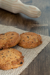 Top view of cookies and rolling pin on cloth and wooden background