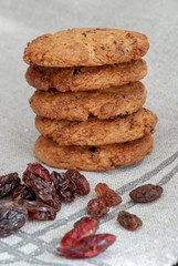 Vertical shot of a stack of cookies and raisins on clear kitchen cloth