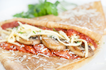 Thin delicious pancake with salami and mushrooms on white