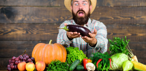 Man with beard wooden background. Farmer with organic vegetables. Excellent quality harvest....