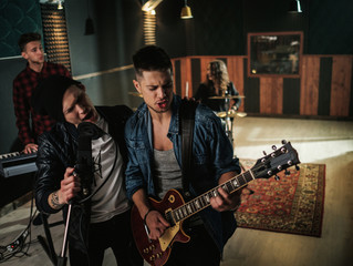 Music band having rehearsal in a studio