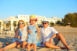 Laughing family with father, mother, daughters having picnic at the beach