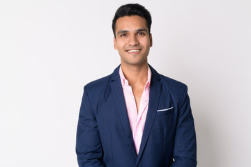 Portrait of young happy Indian businessman in suit smiling