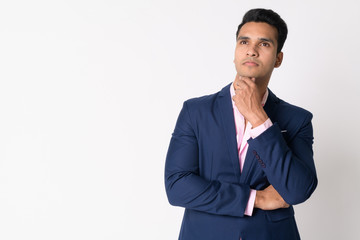 Portrait of young handsome Indian businessman in suit thinking