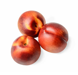 Three nectarines on a white isolated background. View from above. Close-up.