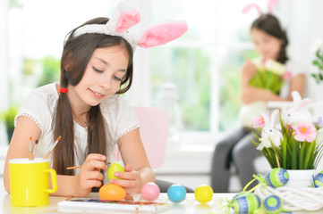 Portrait of cute girl painting eggs for Easter holiday