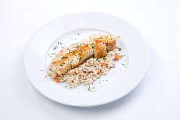 chicken kebab with barley on the white plate