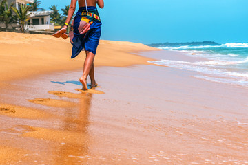 The girl is walking along a tropical beach