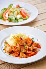 chicken with mashed potatoes and salad on the wooden background
