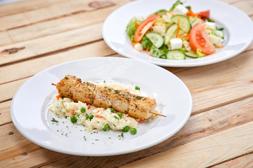 chicken kebab with rice and salad on the wooden background