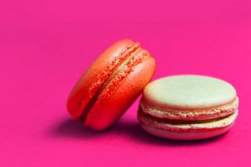 Close-up of orange and beige macaroon cake on pink background