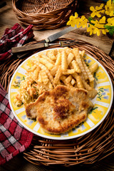 Pork chop, french fries and vegetables.