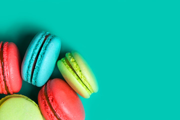 Close up of delicious fresh macaroon on turquoise background with copy space for confectioner