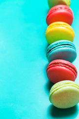 Beautiful turquoise vertical background with colorful macaroons and copy space
