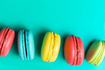 Beautiful fresh macaroon on turquoise background with copy space