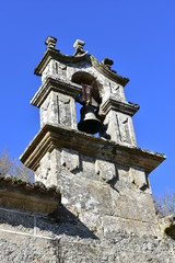 Fototapeta na wymiar Belfry with blue sky, old stone church. Ponte Maceira, Coruña Province, Camino de Santiago, Spain.