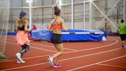 Two young athletic women jogging in covered area