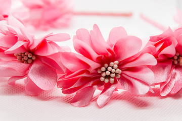 Baby hair accessory with pink flowers on white background