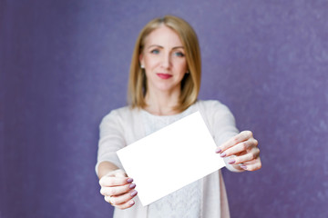 Naklejka premium A woman in bright clothes holding a white sheet on a purple background