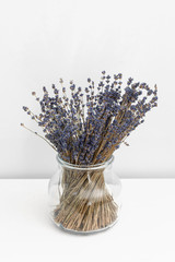 Lavender flowers in glass vase, white wooden background, spa concept, aromatherapy. Lavender flowers in close up