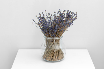 Lavender flowers in glass vase, white wooden background, spa concept, aromatherapy. Lavender flowers in close up
