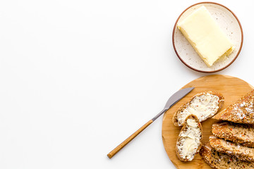 Slice of bread with butter on white background top view copy space