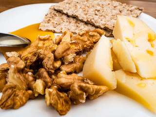 tasty Italian healthy rustic breakfast with homemade cow's milk cheese, walnuts, honey and sesame biscuits
