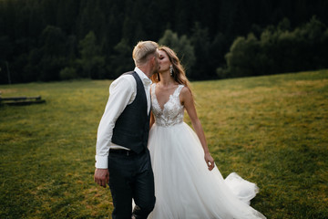 Beautiful wedding couple, bride and groom, in love on the background of mountains