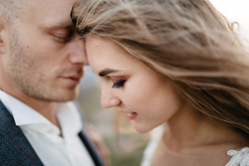 Beautiful wedding couple, bride and groom, in love on the background of mountains