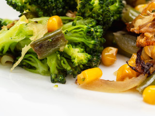 cooked vegetables broccoli, carrots, green beans, corn on a white plate. macro