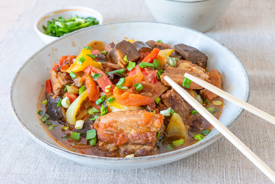 Fried pork with eggplants and sweet peppers in a large bowl - a traditional Chinese dish