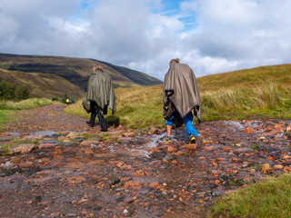 two girls hiking on a wet hiking path in sunny weather