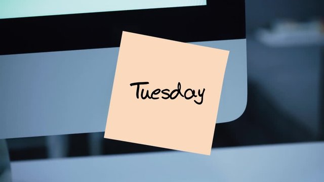 Tuesday. Days of the week. The inscription on the sticker on the monitor. Message. Motivation. Reminder. Handwritten text written with a marker. Color sticker. A message for an employee, a colleague
