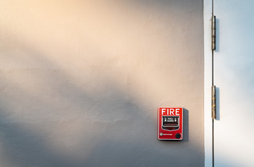 Fire alarm on dark gray concrete wall. Warning and security system. Emergency equipment for safety...