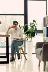 Pleasant nice woman sitting in her office