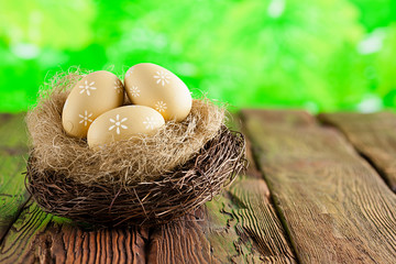 Easter eggs in the nest on wooden table