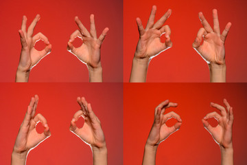Two human hands show a sign ok, isolated on a red background