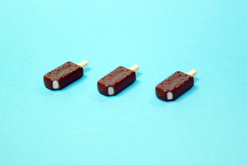 Fototapeta premium classic bitten popsicles choc-ice Lollipop ice cream in chocolate glaze on blue pastel background