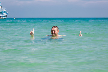 Happy caucasian man bathing in the sea in Thailand