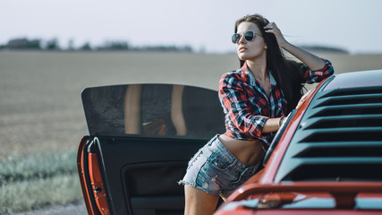brunette girl posing near the car