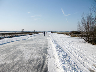 Dutch landscape of frozen canals, with ice skaters